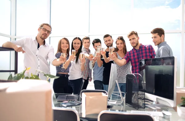 Улыбающаяся бизнес-команда, стоящая в новом офисе — стоковое фото