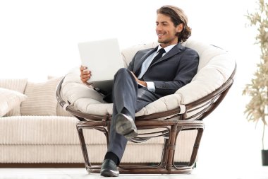 şık rahat sandalyede oturan bir dizüstü bilgisayar ile modern iş adamı