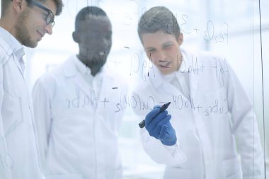 genç bilim adamı notlar bir cam Yönetim Kurulu yapar.