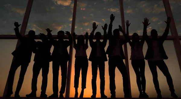 Silueta de un grupo de empresarios levantando la mano — Foto de Stock