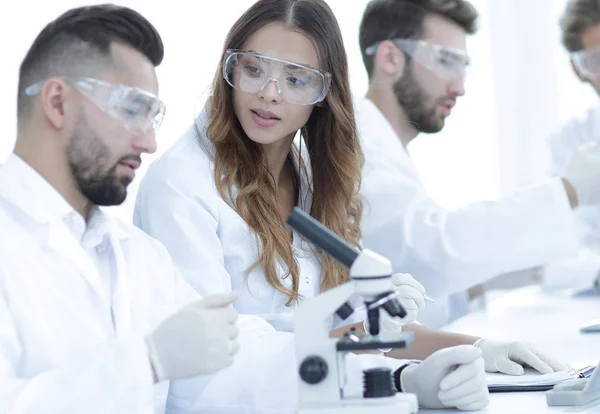 Jóvenes científicos discutiendo los resultados de los experimentos en el laboratorio — Foto de Stock