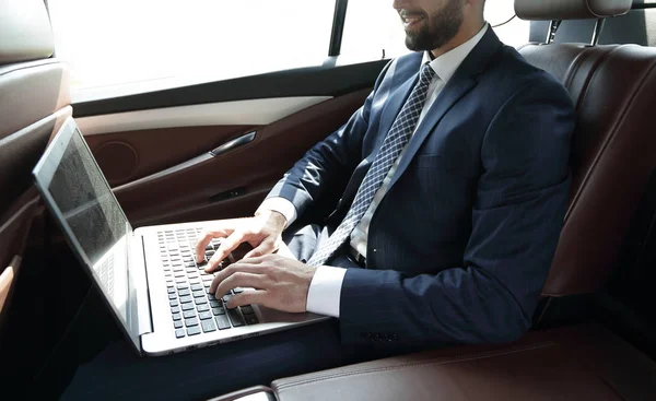 Empresario trabajando con el ordenador portátil sentado en el coche —  Fotos de Stock