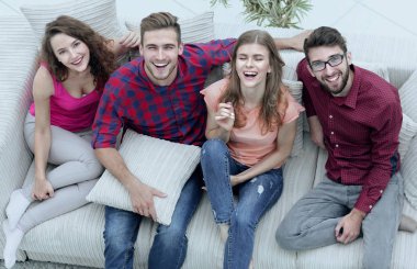 dört mutlu arkadaş kanepede otururken gülüyor