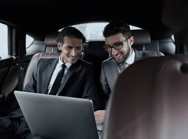 Two businessman talking while sitting in the car — Stock Photo, Image