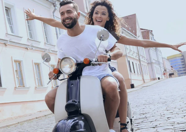 Glückliches junges Paar, das Spaß auf einem Roller hat — Stockfoto