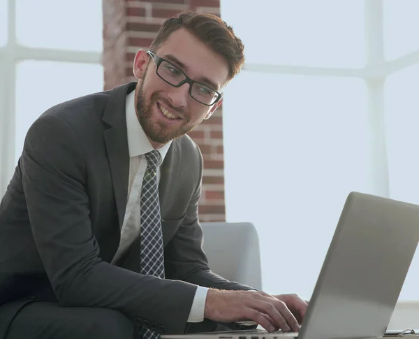 Uomo d'affari con gli occhiali è seduto alla scrivania in ufficio — Foto Stock