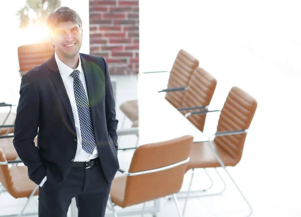 Hombre de negocios de pie en una sala de reuniones vacía — Foto de Stock