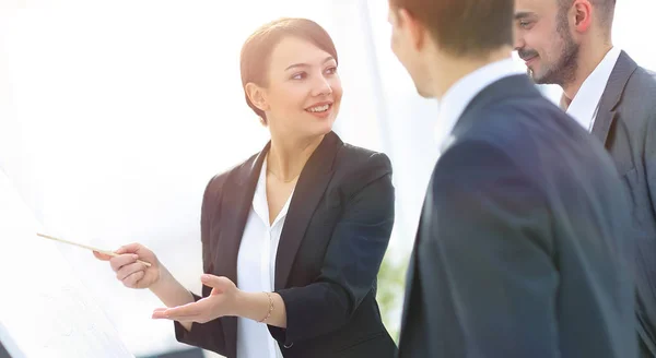 Mujer de negocios mostrando información de un equipo de negocios en el rotafolio — Foto de Stock