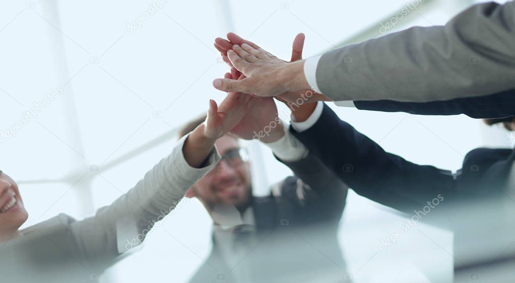 happy business team giving high five in office