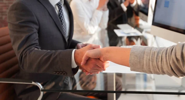 Zakenman die zijn handen schudden met een zakenpartner zitten in de buurt van uw bureaublad — Stockfoto