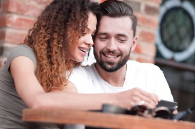 Seven bir terasta yer oturan bir smartphone kullanarak çift mutlu