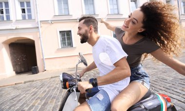 mutlu genç bir çift bir scooter üzerinde eğleniyor