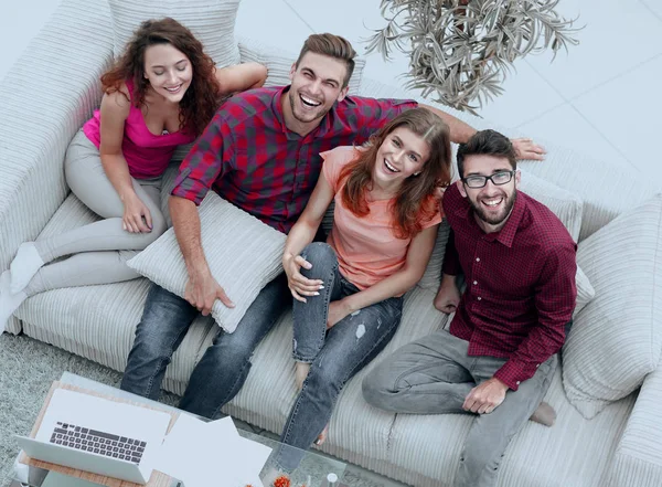 view from the top.a group of laughing friends sitting on the sof