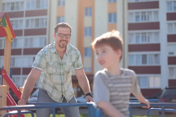 Lycklig far leker med liten pojke på lekplatsen — Stockfoto