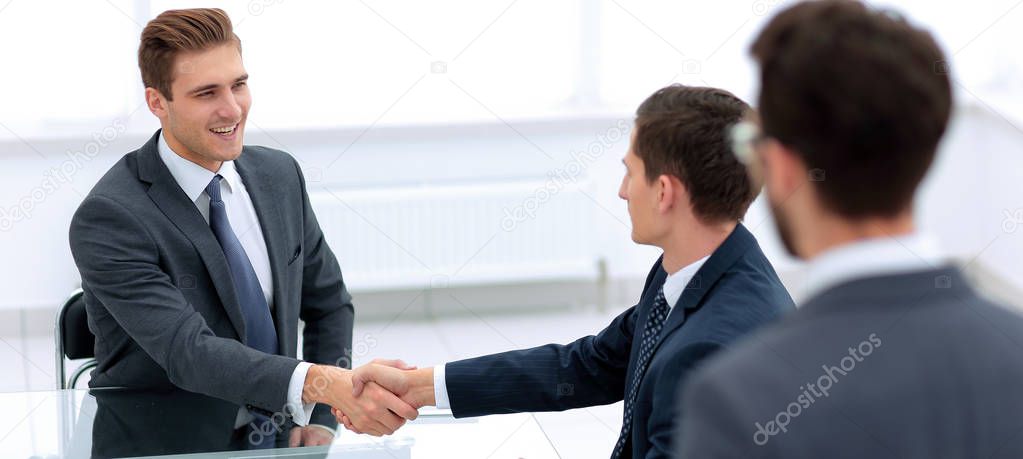 handshake business partners in the office