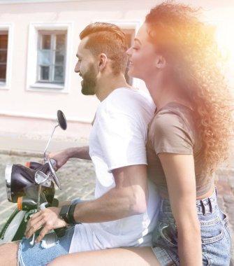 mutlu genç bir çift bir scooter üzerinde eğleniyor