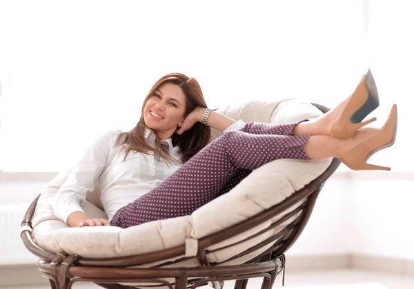 坐在舒适的椅子的快乐的妇女 — 图库照片