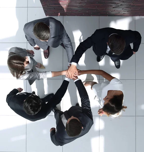 Bovenaanzicht. een groep van mensen uit het bedrijfsleven met hun handen opgevouwen — Stockfoto