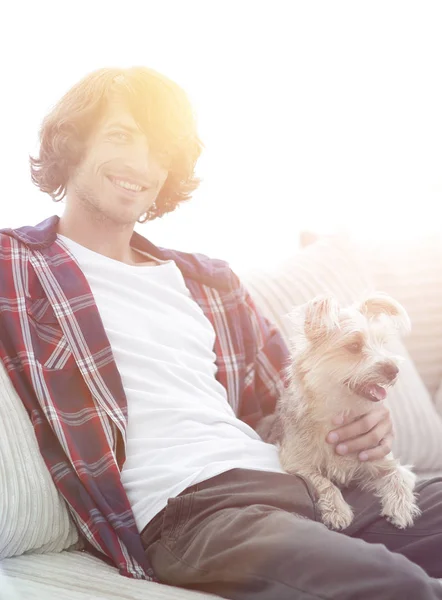 Ragazzo elegante seduto sul divano con il suo cane . — Foto Stock