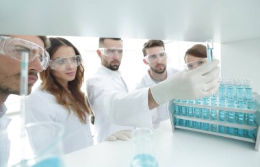 arka plan görüntüsü sıvı cam tüp içinde eğitim microbiologists oluşan bir gruptur.