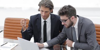 dizüstü bilgisayarda çalışan iki iş adamı