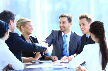 Toplantı üzerinde el sıkışan iki iş ortakları