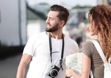 Genç çift mutlu görünürken bir rehbere bakıyor.