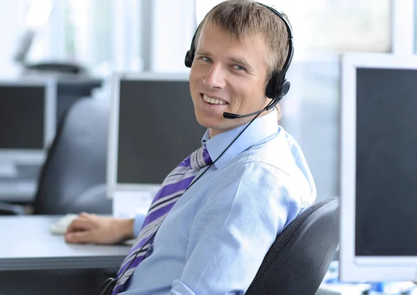 Homme d'affaires heureux dans un casque souriant tout en regardant la caméra . — Photo