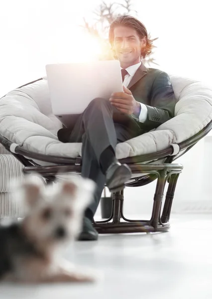 Homme d'affaires réussi avec ordinateur portable assis dans un grand armchai confortable — Photo