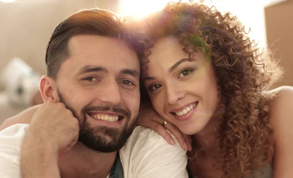 Pareja feliz acostada en la alfombra sobre el fondo borroso — Foto de Stock