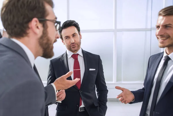 Gerente y empleados de la empresa hablando de pie en la oficina —  Fotos de Stock