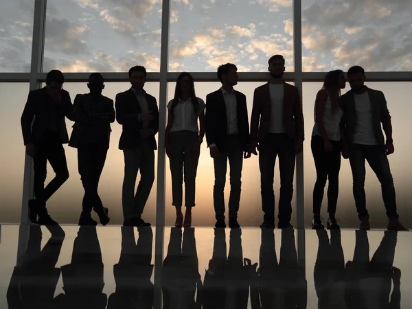 Silhouette di un team di lavoro in piedi accanto alla finestra dell'ufficio — Foto Stock