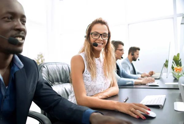Young business woman sitting at table in call center — Stock Photo, Image