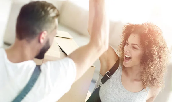 Pareja joven dando cinco cuando se muda a un nuevo apartamento — Foto de Stock