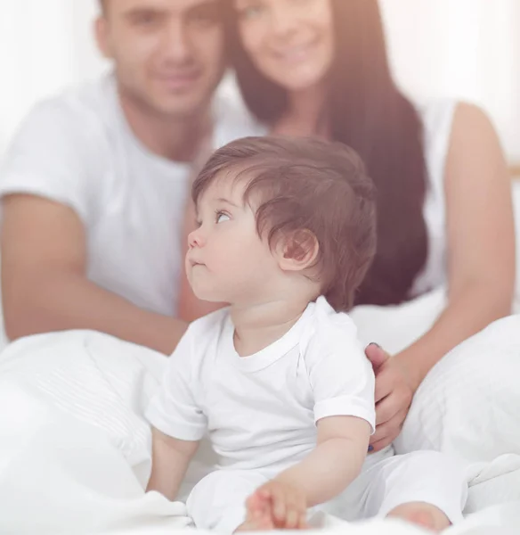 Feliz pareja e hijo sentado en la cama —  Fotos de Stock