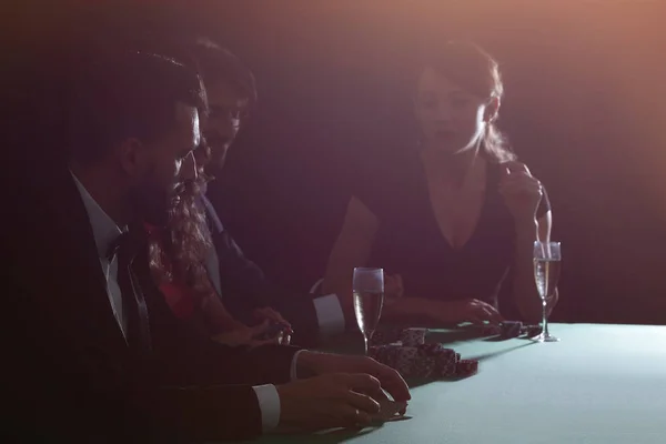Вид сбоку на группу людей, играющих вместе в покер в казино — стоковое фото