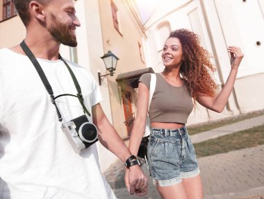 Bir çift şehrin sokaklarında yürüyor ve eğleniyor.