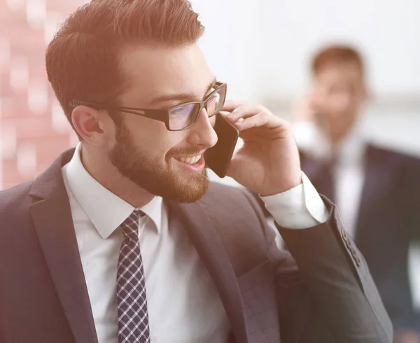 Knappe zakenman spreken op mobiele telefoon in kantoor — Stockfoto
