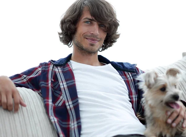 şık adam köpeğiyle kanepede oturan.