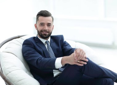 Kendine güvenen işadamı bir sandalyede oturuyor