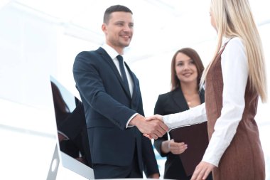 başarılı bir sunum sonrası el sıkışan iş arkadaşları.