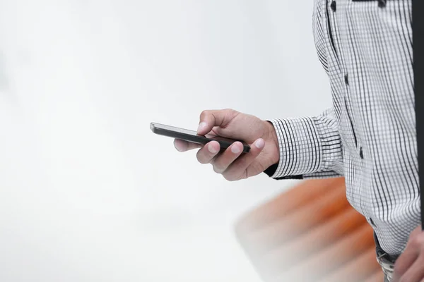 Primer plano. Un hombre sostiene un teléfono inteligente . — Foto de Stock