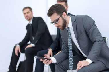 Grup ofis alma içinde oturan bir toplantı için bekleyen iş adamları.