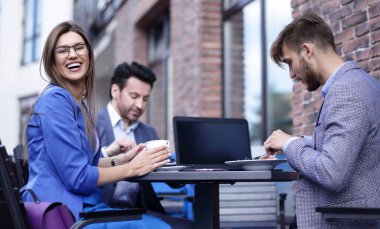 bir kafede bir masada oturan çalışanlar