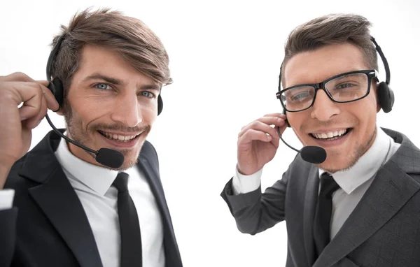 Hombre de negocios sonriente hablando con auriculares contra un fondo blanco —  Fotos de Stock