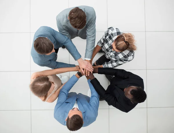 Vista dall'alto delle persone che mettono insieme le mani — Foto Stock