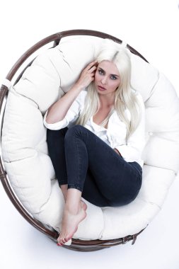 Güzel bir üzücü genç kadının büyük bir rahat koltuğa oturma portre
