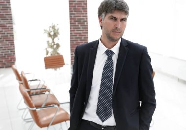 Bir boş toplantı odasında duran iş adamı