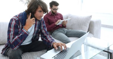 iki adam kanepede oturan, belgili tanımlık smartphone üzerinde konuşmak ve Internet üzerinde iletişim.