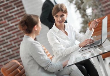 Kadın Yönetici dizüstü bilgisayardan müşteri bilgilerini gösterir..